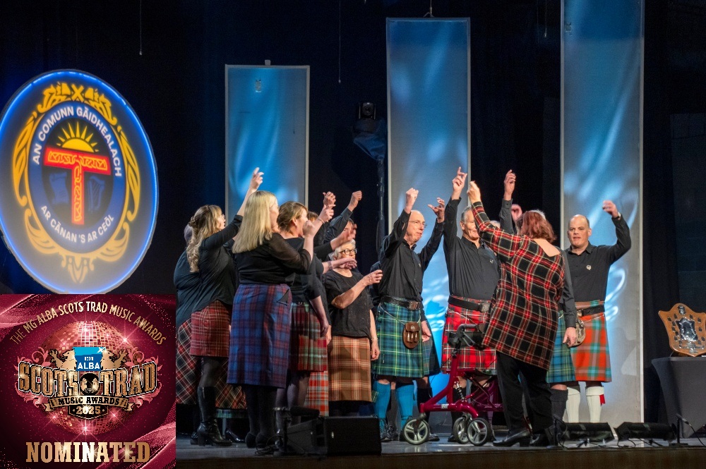 Choir on stage at Mòd with Hands Up For Trad logo